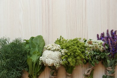 Photo of Bunches of different beautiful dried flowers and herbs on white wooden table, flat lay. Space for text