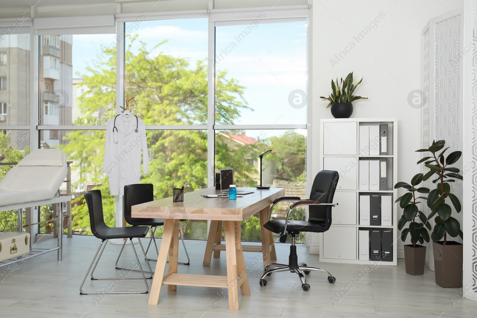 Photo of Modern medical office interior with doctor's workplace near window