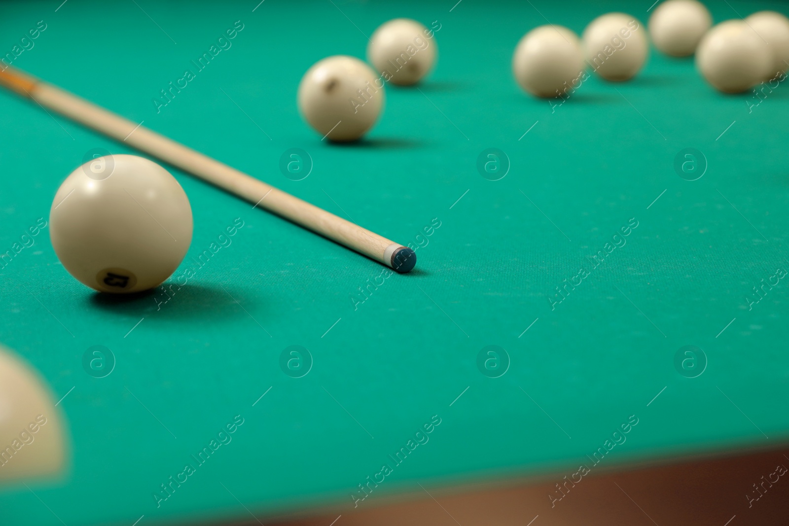 Photo of Balls and cue on modern billiard table