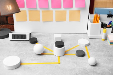 Business process scheme with geometric figures and stationery on light grey table