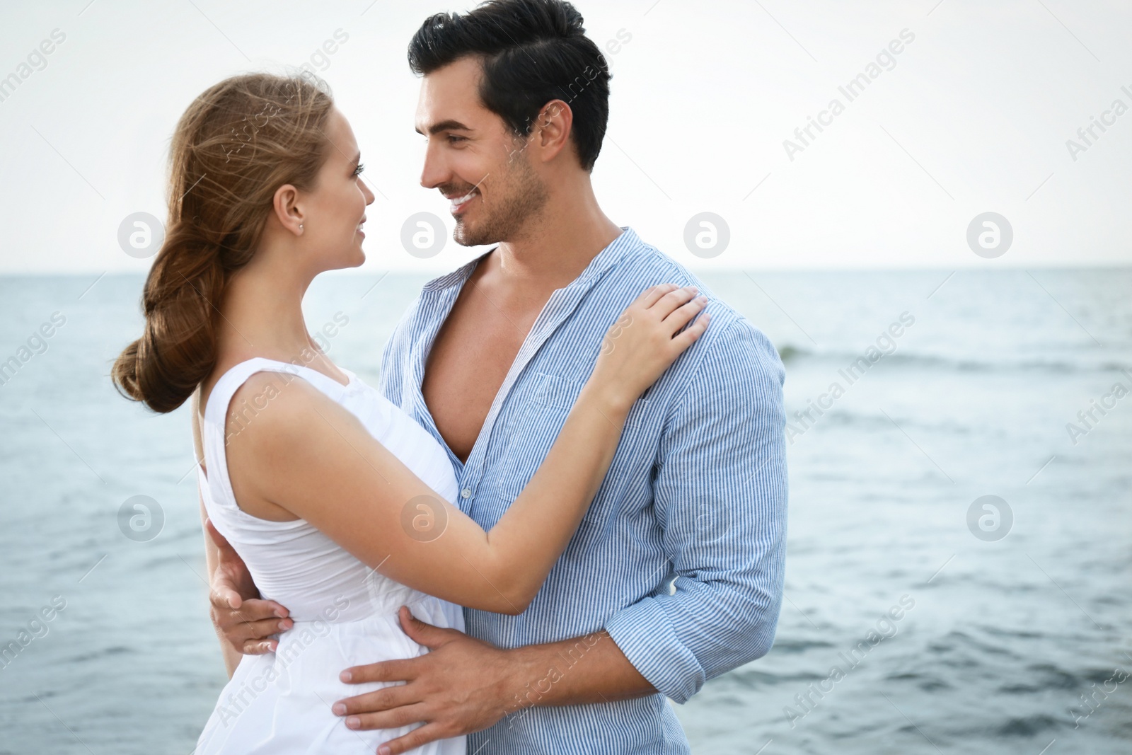 Photo of Happy young couple spending time at sea beach