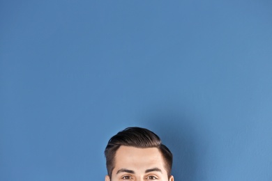 Man with beautiful hair on color background, closeup