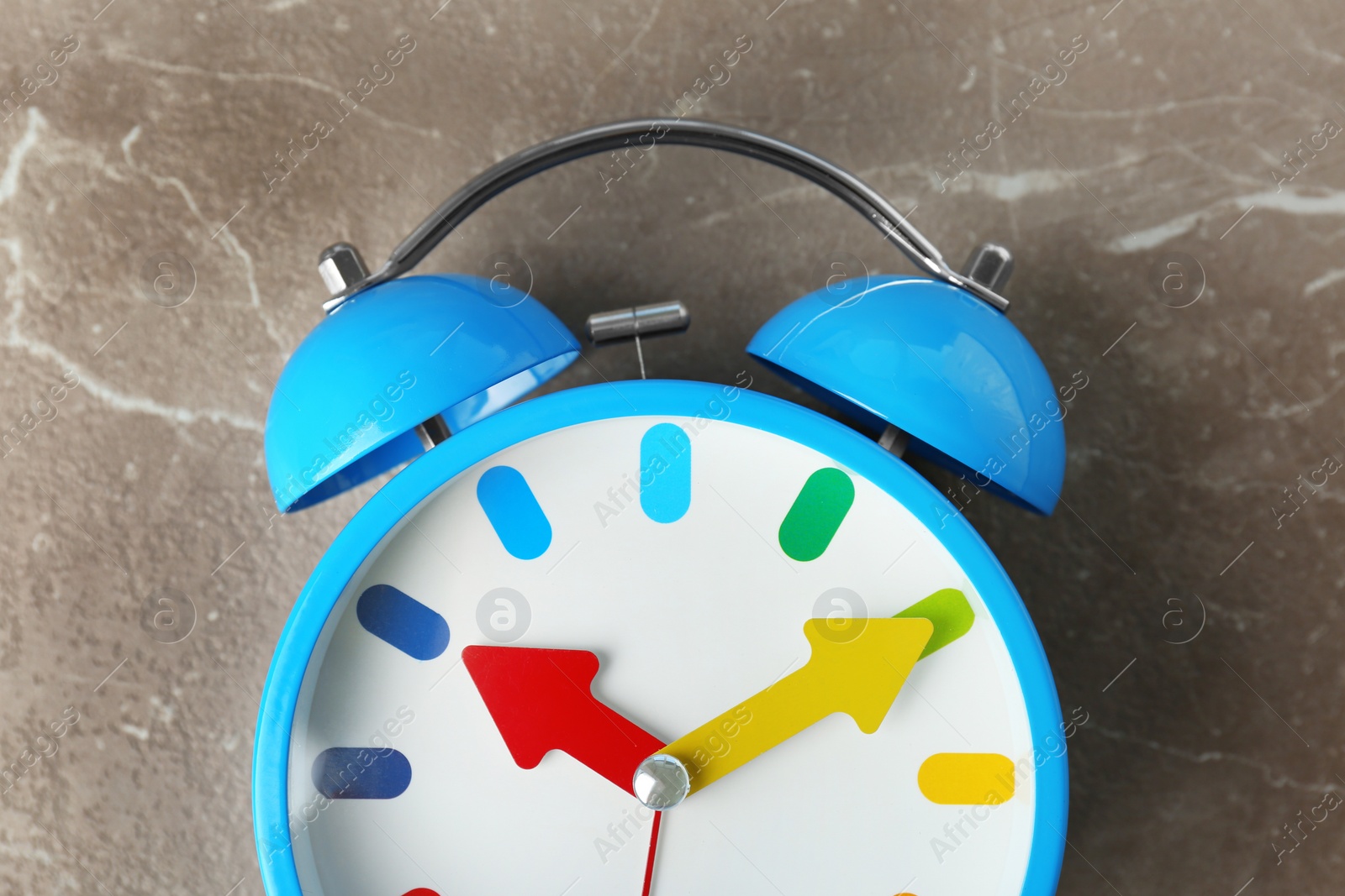 Photo of Colorful alarm clock on table, closeup. Time change concept