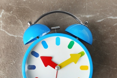 Photo of Colorful alarm clock on table, closeup. Time change concept