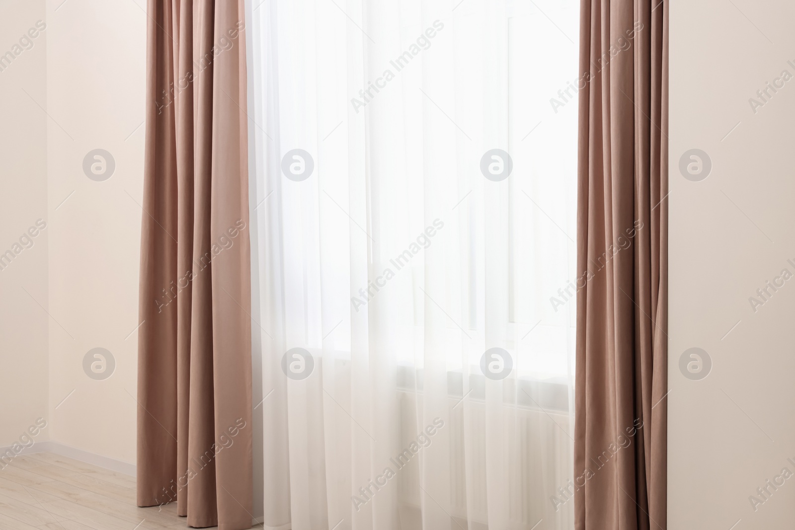 Photo of Elegant window curtains and white tulle indoors. Interior design