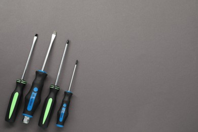 Photo of Set of screwdrivers on grey background, flat lay. Space for text