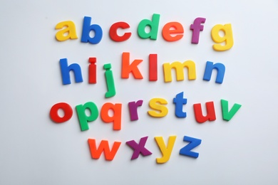 Photo of Plastic magnetic letters isolated on white, top view. Alphabetical order