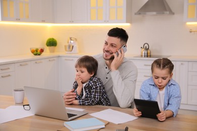 Happy man combining parenting and work at home