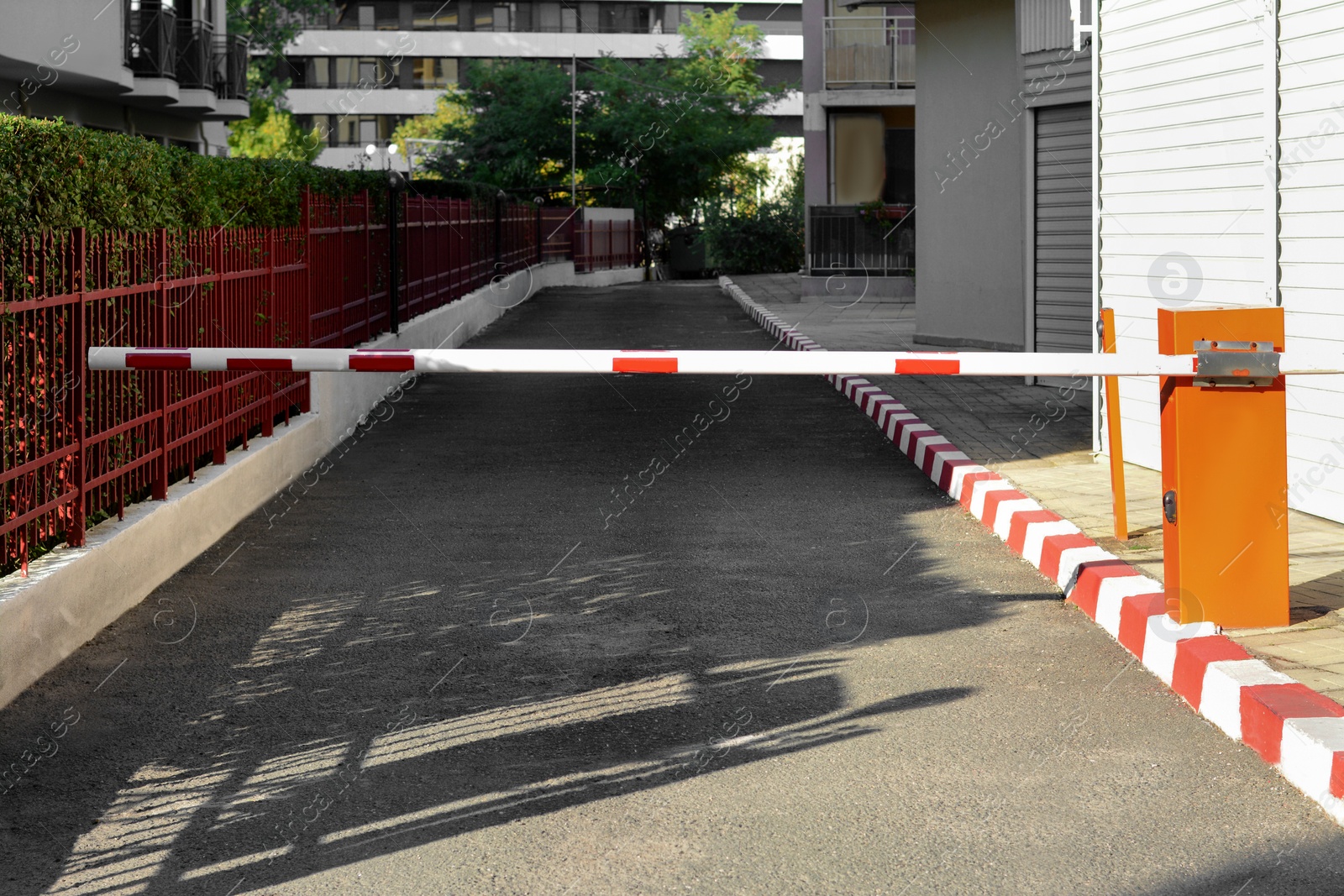 Photo of Closed boom barrier near road on sunny day outdoors