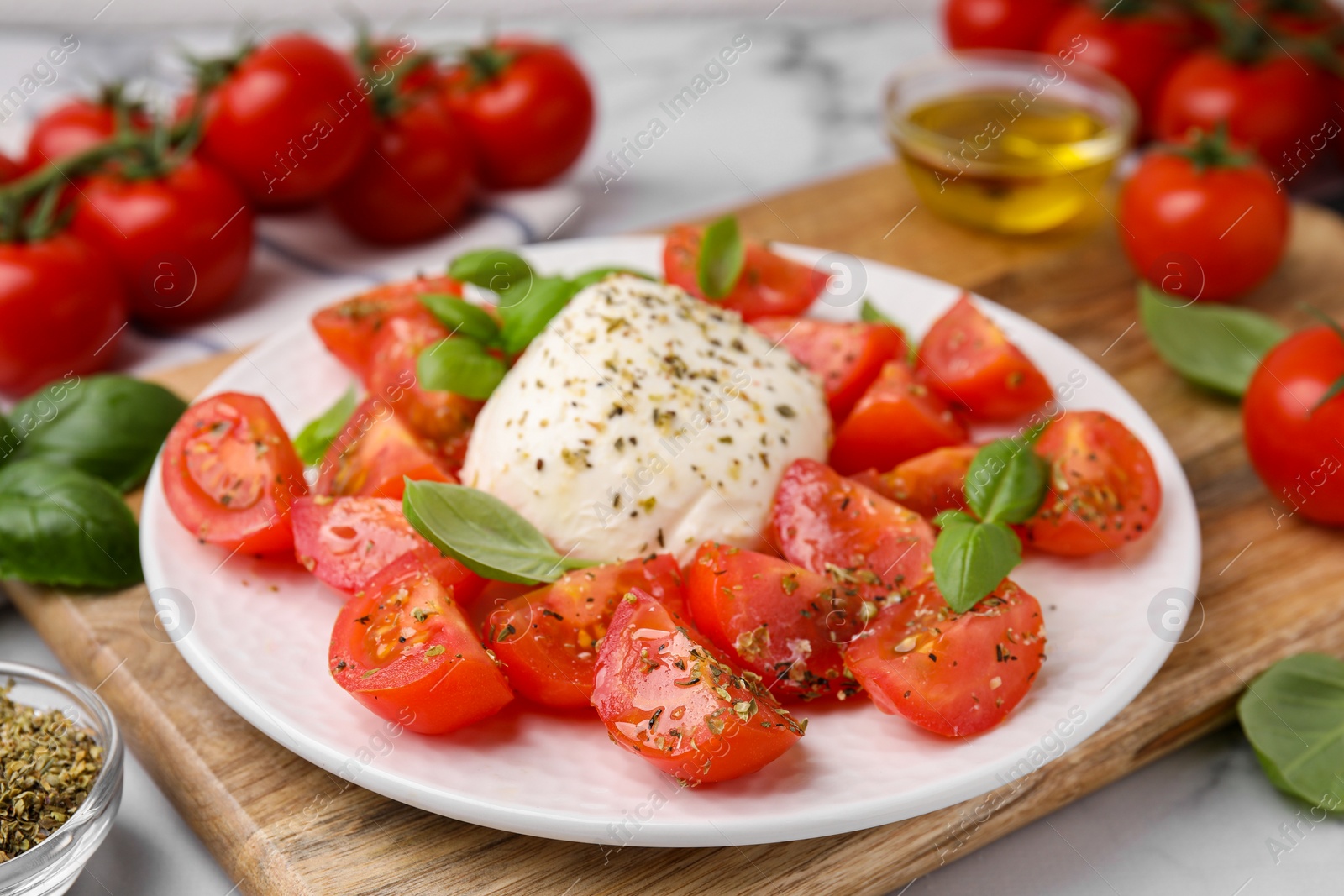 Photo of Tasty salad Caprese with mozarella, tomatoes and basil on table, closeup