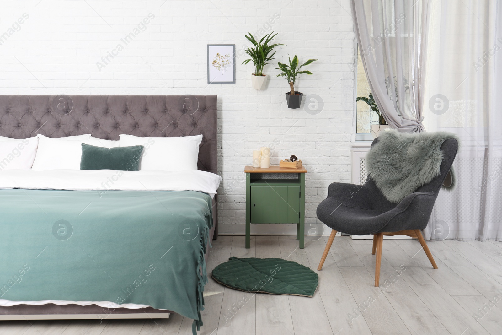 Photo of Stylish interior with comfortable double bed and armchair