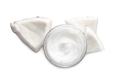 Jar of hand cream and coconut pieces on white background, top view