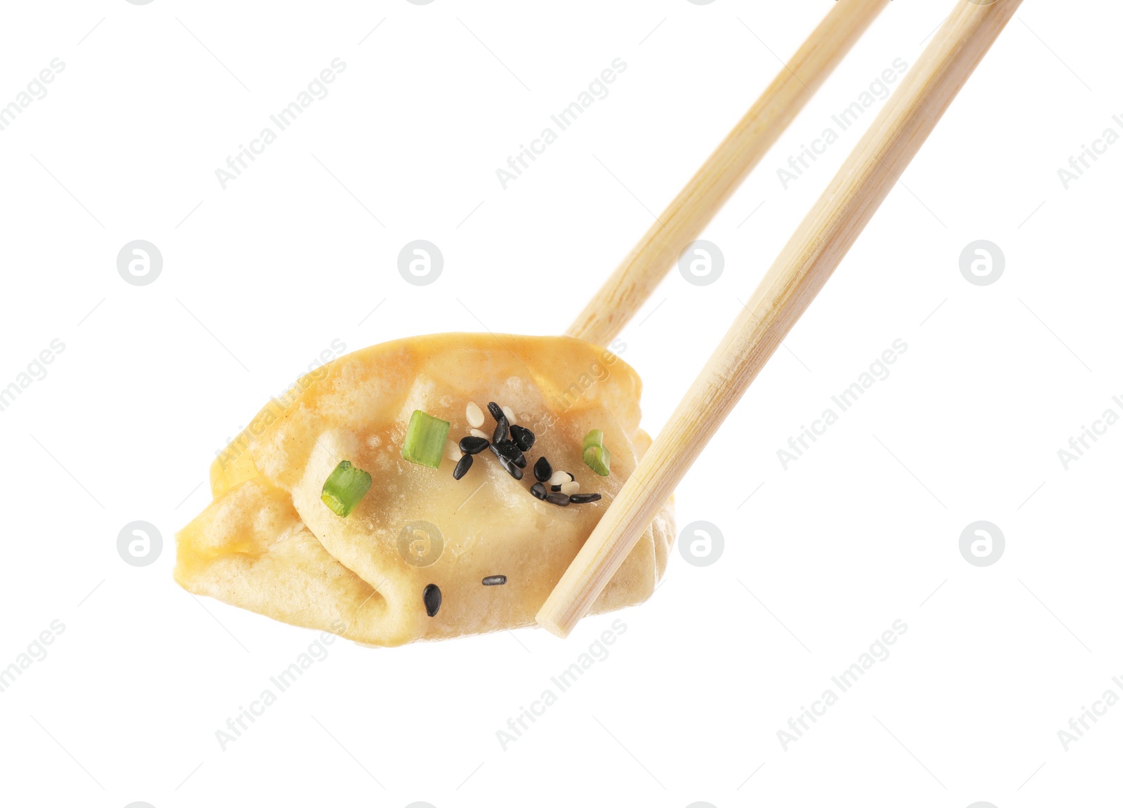 Photo of Chopsticks with delicious gyoza (asian dumpling), onion and sesame isolated on white