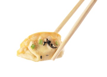 Photo of Chopsticks with delicious gyoza (asian dumpling), onion and sesame isolated on white