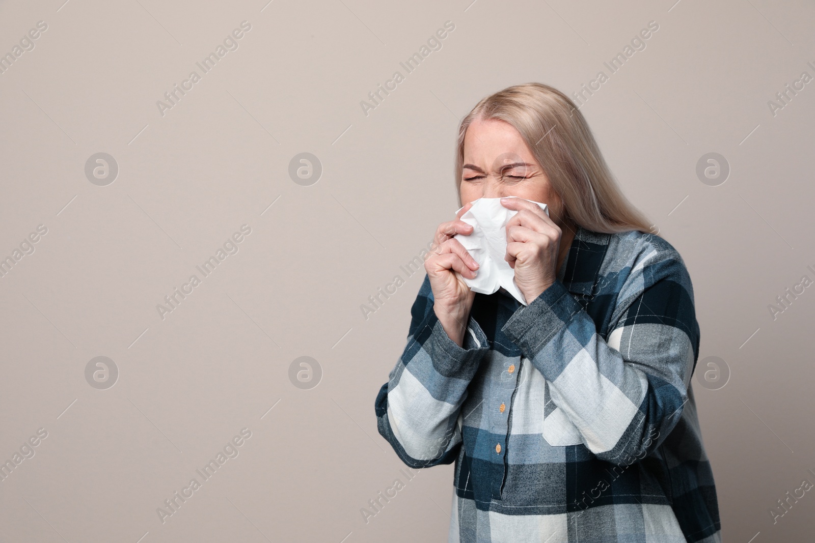 Photo of Sick mature woman on beige background, space for text. Dangerous virus