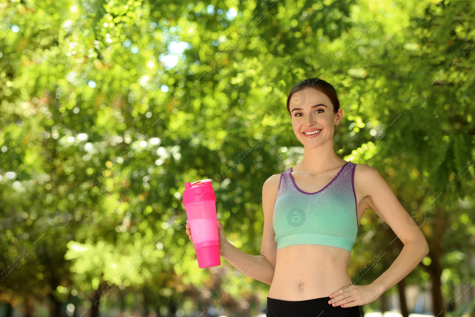 Photo of Athletic young woman with protein shake at green park