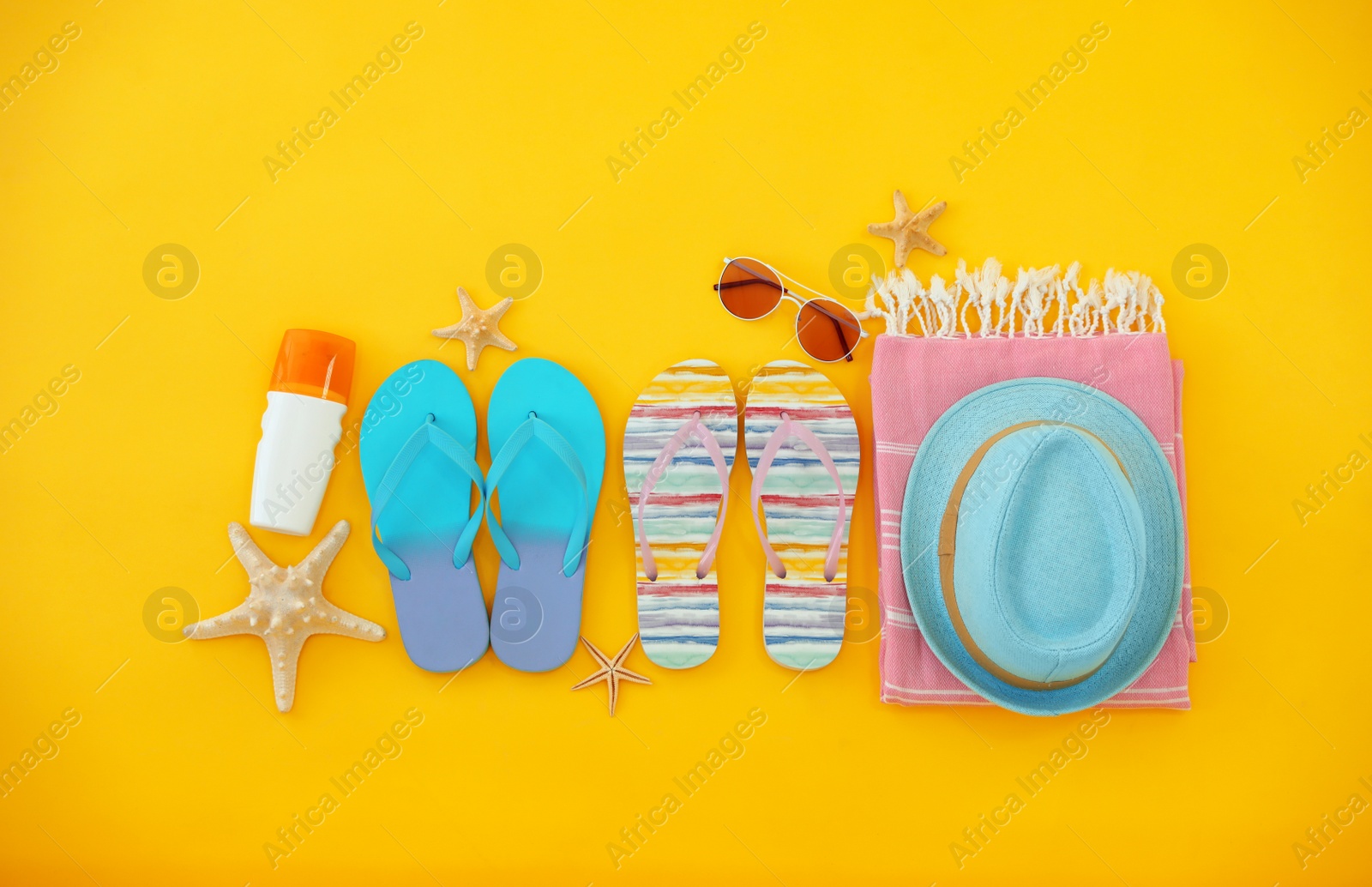 Photo of Flat lay composition with summer beach accessories on yellow background