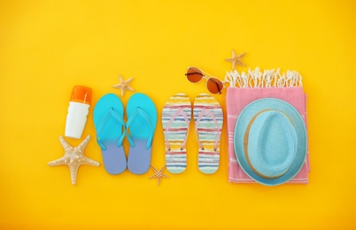 Photo of Flat lay composition with summer beach accessories on yellow background