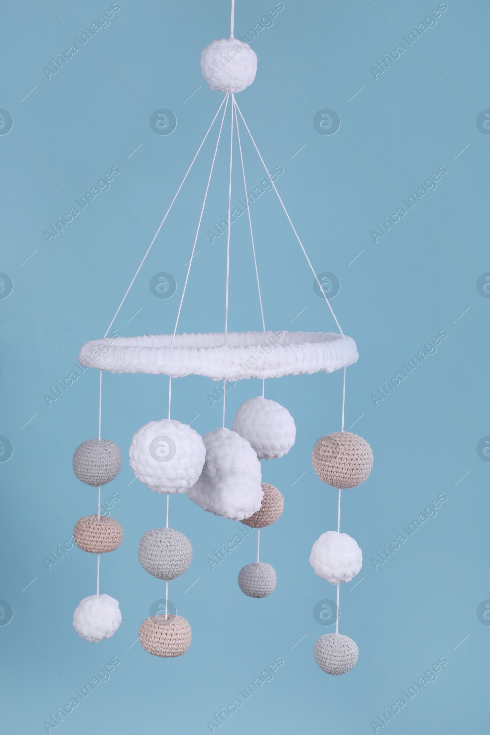 Photo of Cute baby crib mobile on light blue background