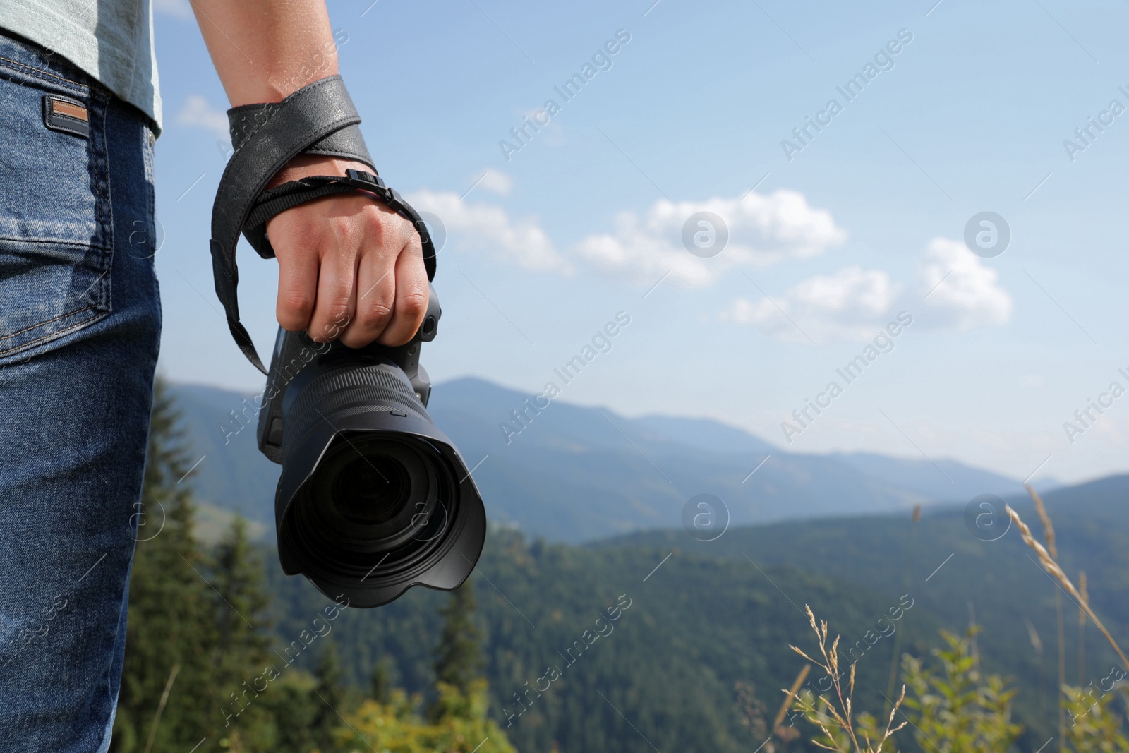 Photo of Professional photographer with modern camera in mountains, closeup. Space for text
