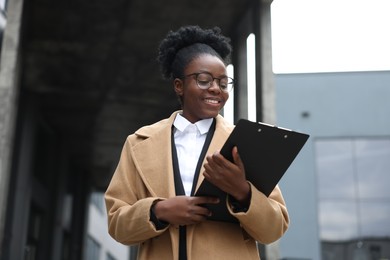 Happy woman with clipboard outdoors. Lawyer, businesswoman, accountant or manager