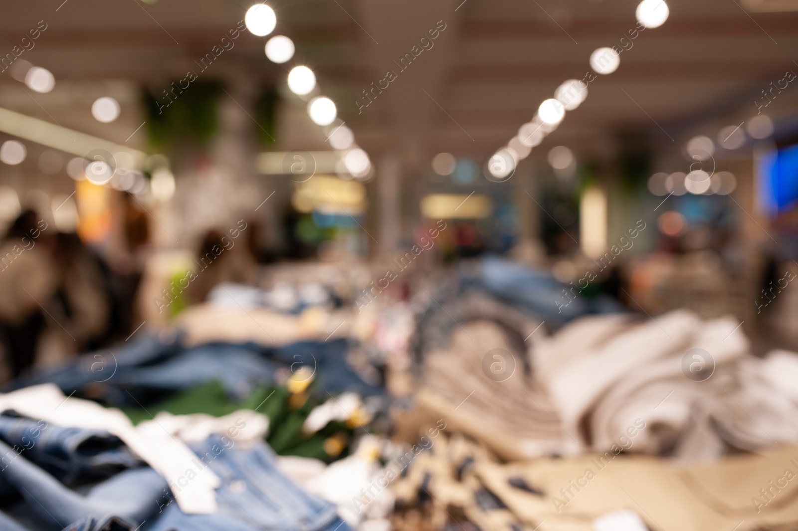 Photo of Blurred view of modern boutique interior with stylish clothes