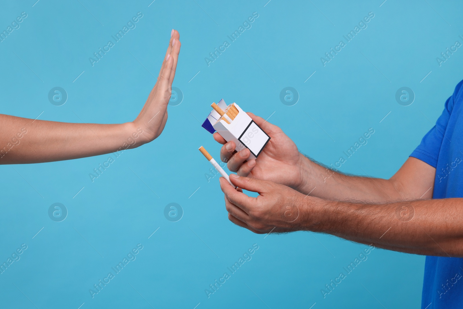 Photo of Stop smoking concept. Woman refusing cigarettes on light blue background, closeup