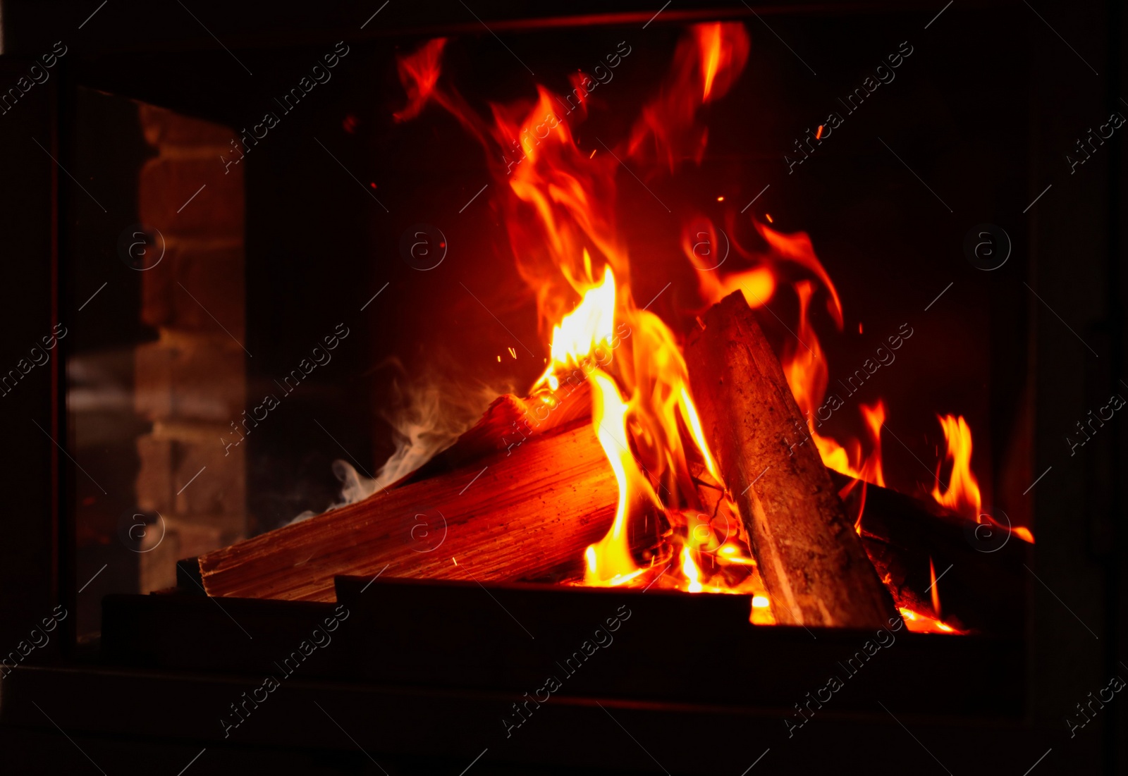 Photo of Fireplace with burning wood, closeup view. Winter vacation