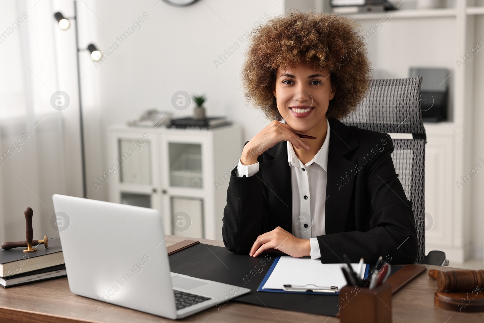 Photo of Notary with clipboard and pen at workplace in office