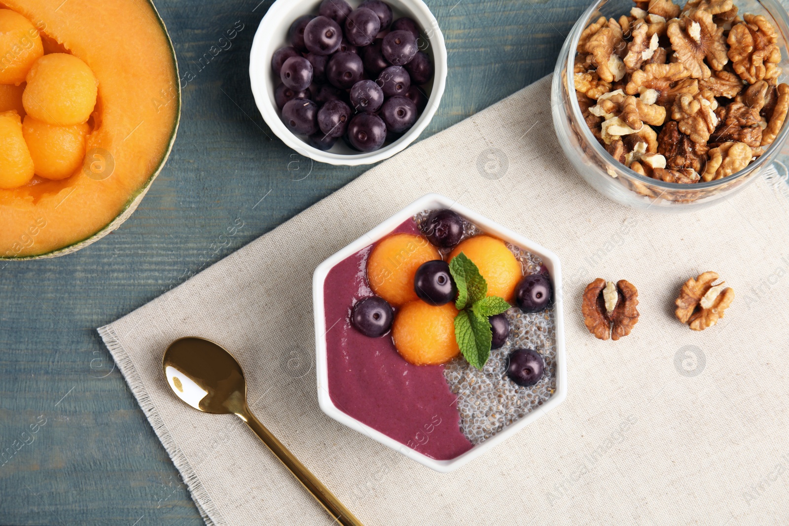 Photo of Flat lay composition with bowl of tasty acai smoothie on wooden table