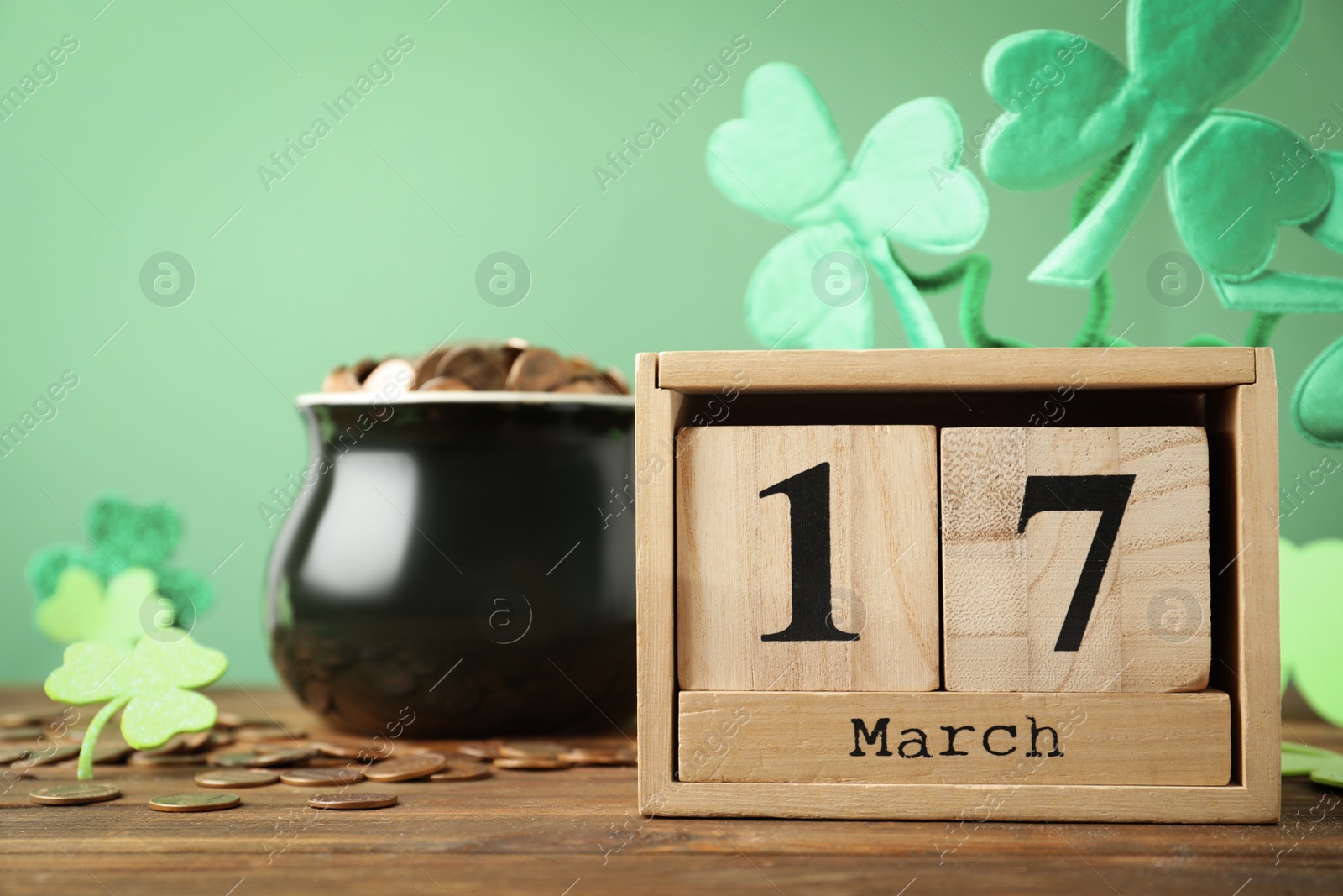 Photo of Composition with block calendar on wooden table. St. Patrick's Day celebration