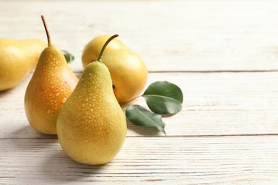 Ripe pears on wooden table. Space for text