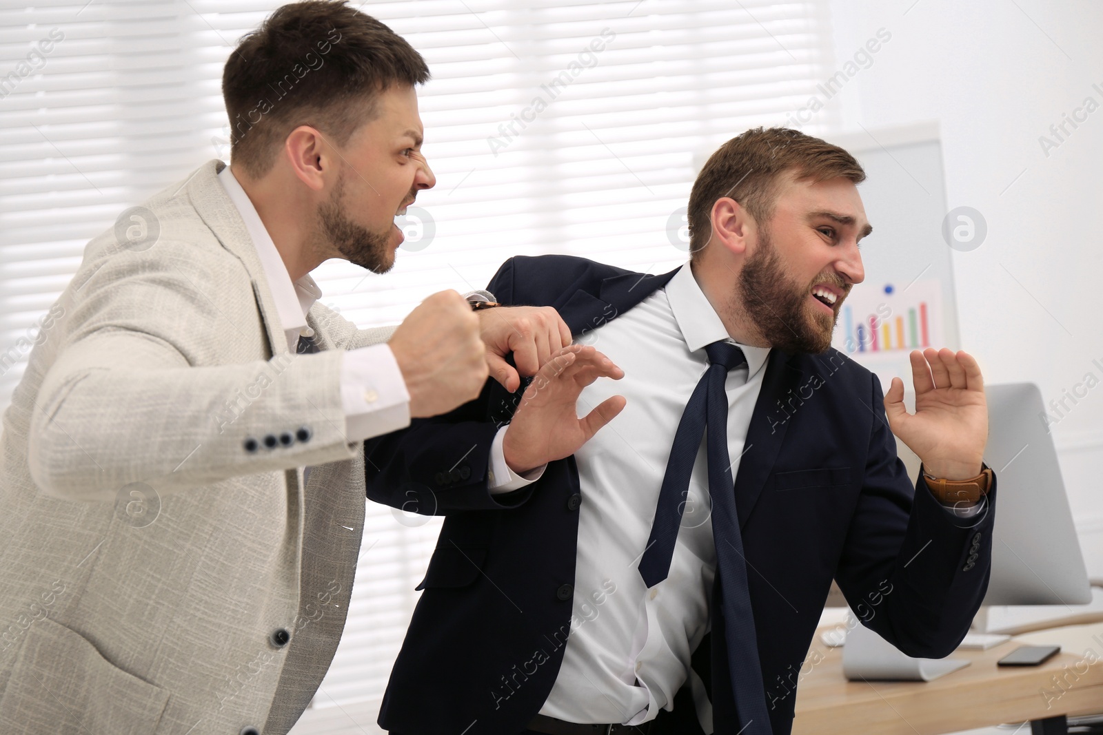 Photo of Emotional colleagues fighting in office. Workplace conflict