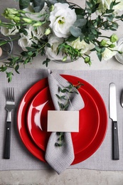 Elegant festive table setting with blank card on grey background, flat lay