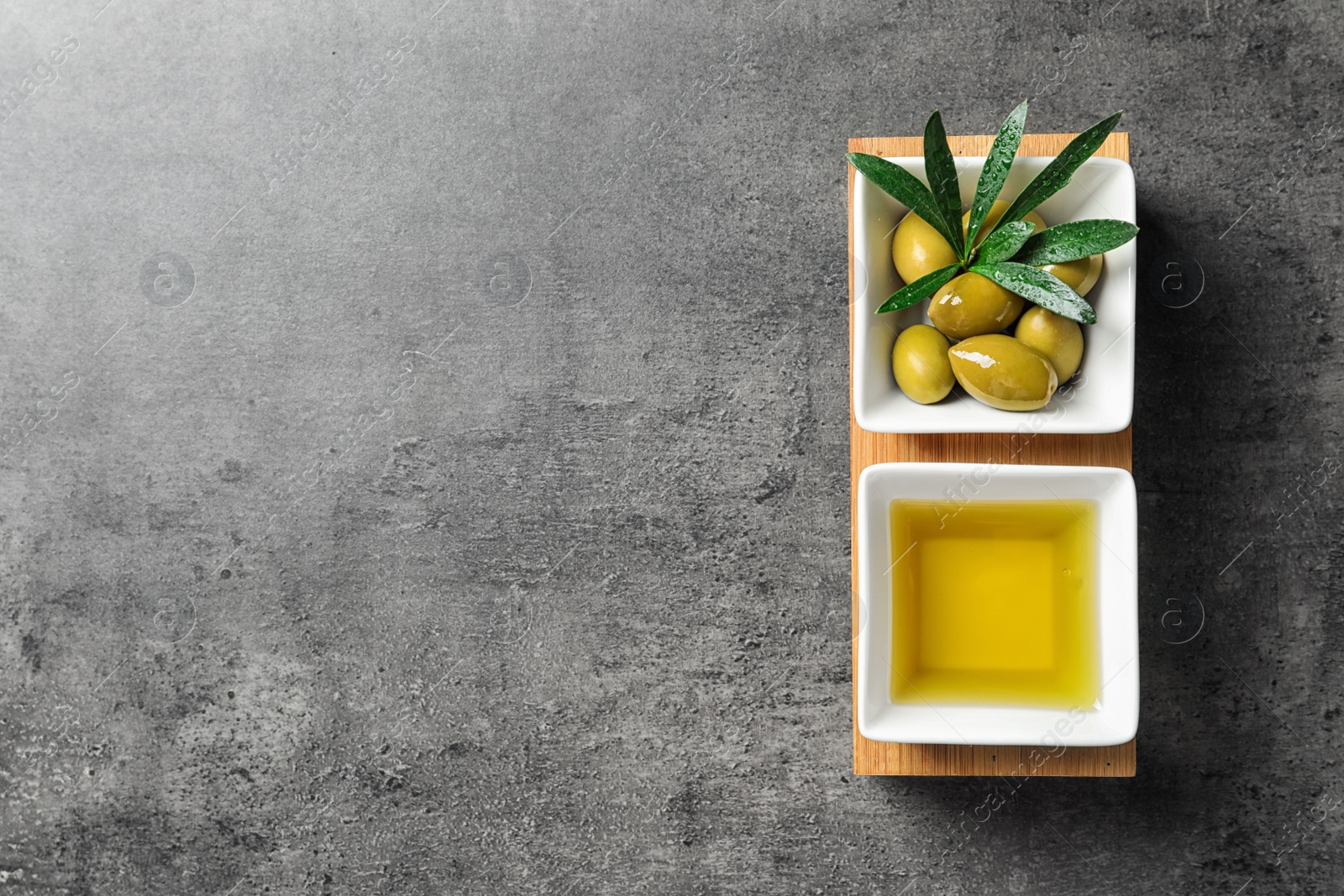 Photo of Dishes with olive oil and ripe olives on table, top view