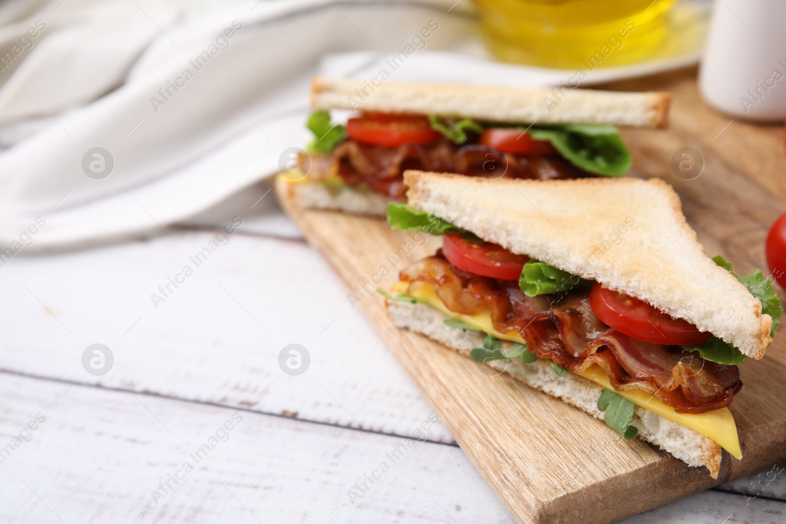 Photo of Delicious sandwiches with fried bacon on wooden rustic table, closeup. Space for text