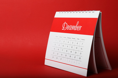 Photo of Paper calendar on red background, space for text. Planning concept