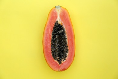 Photo of Half of fresh ripe papaya fruit on light green background, top view