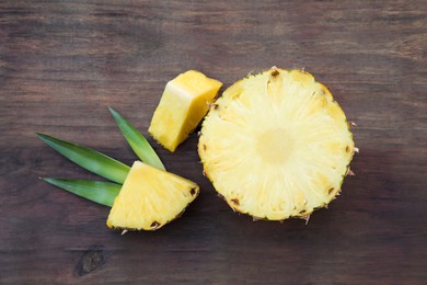 Delicious cut ripe pineapple on wooden table, flat lay