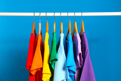 Photo of Bright clothes on blue background. Rainbow colors