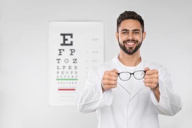 Photo of Male ophthalmologist with eyeglasses in clinic. Space for text