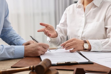 Photo of Lawyers working with documents at table in office, closeup