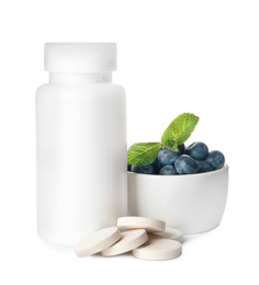 Photo of Bottle with vitamin pills and blueberries on white background