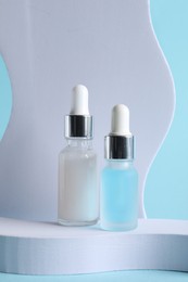 Stylish presentation of cosmetic serum on light blue background