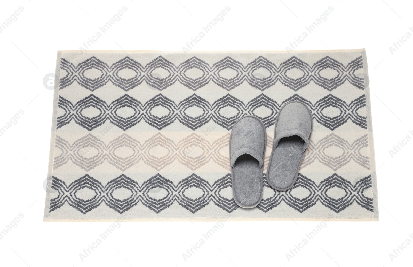 Photo of Soft bath mat and slippers isolated on white, top view