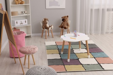 Photo of Child`s playroom with different toys and modern furniture. Stylish kindergarten interior
