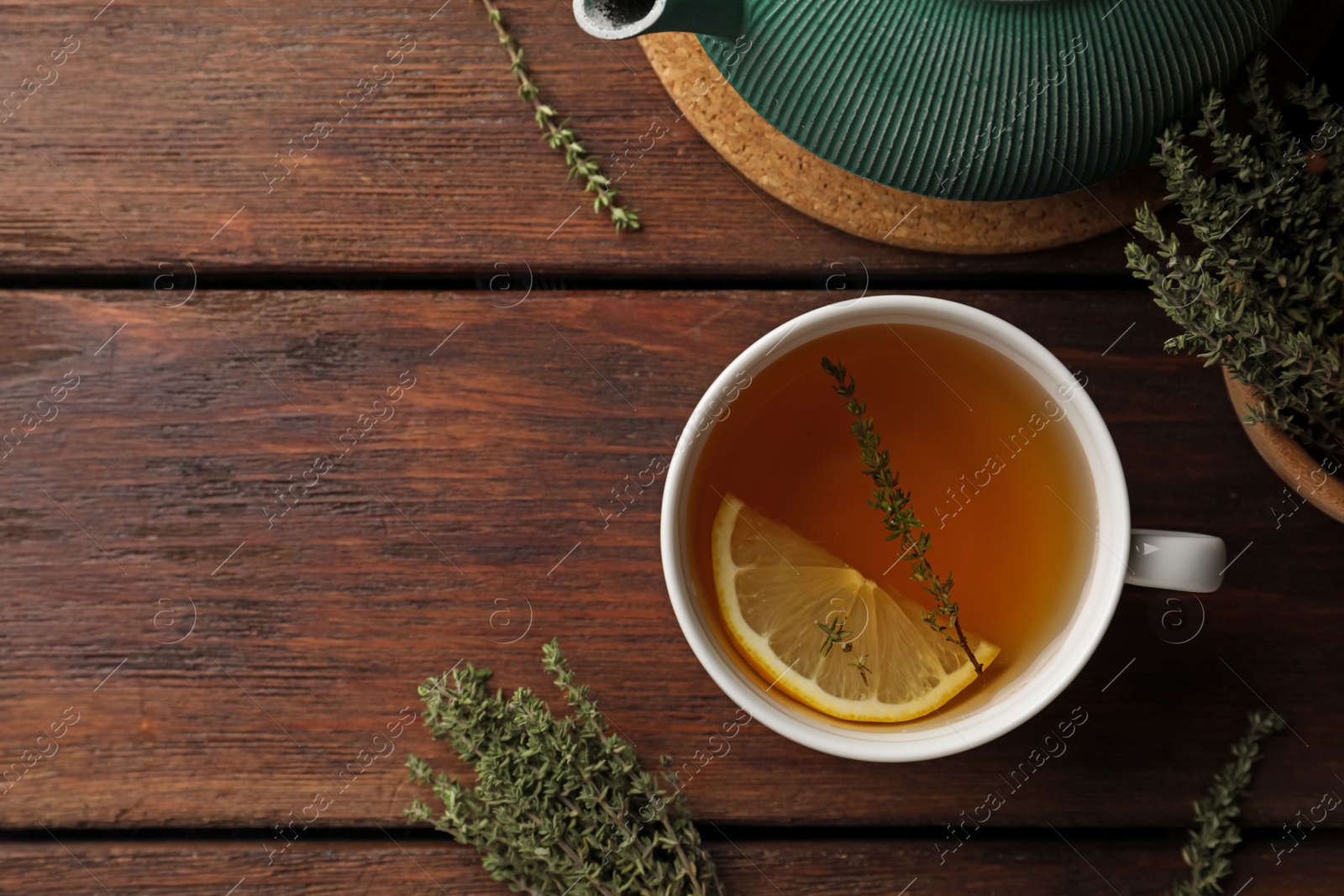 Photo of Aromatic herbal tea with thyme and lemon on wooden table, flat lay. Space for text