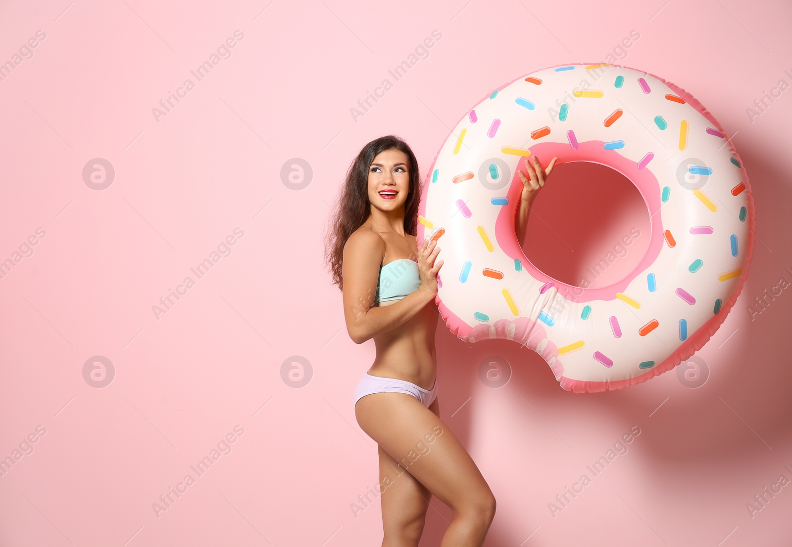 Photo of Beautiful young woman with inflatable ring on color background