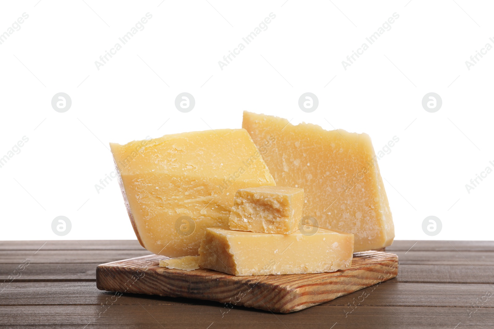 Photo of Pieces of delicious parmesan cheese on wooden table against white background