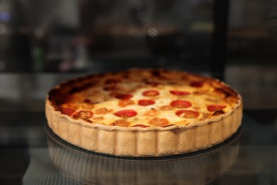 Photo of Delicious quiche with shrimps on counter in bakery shop, closeup. Space for text